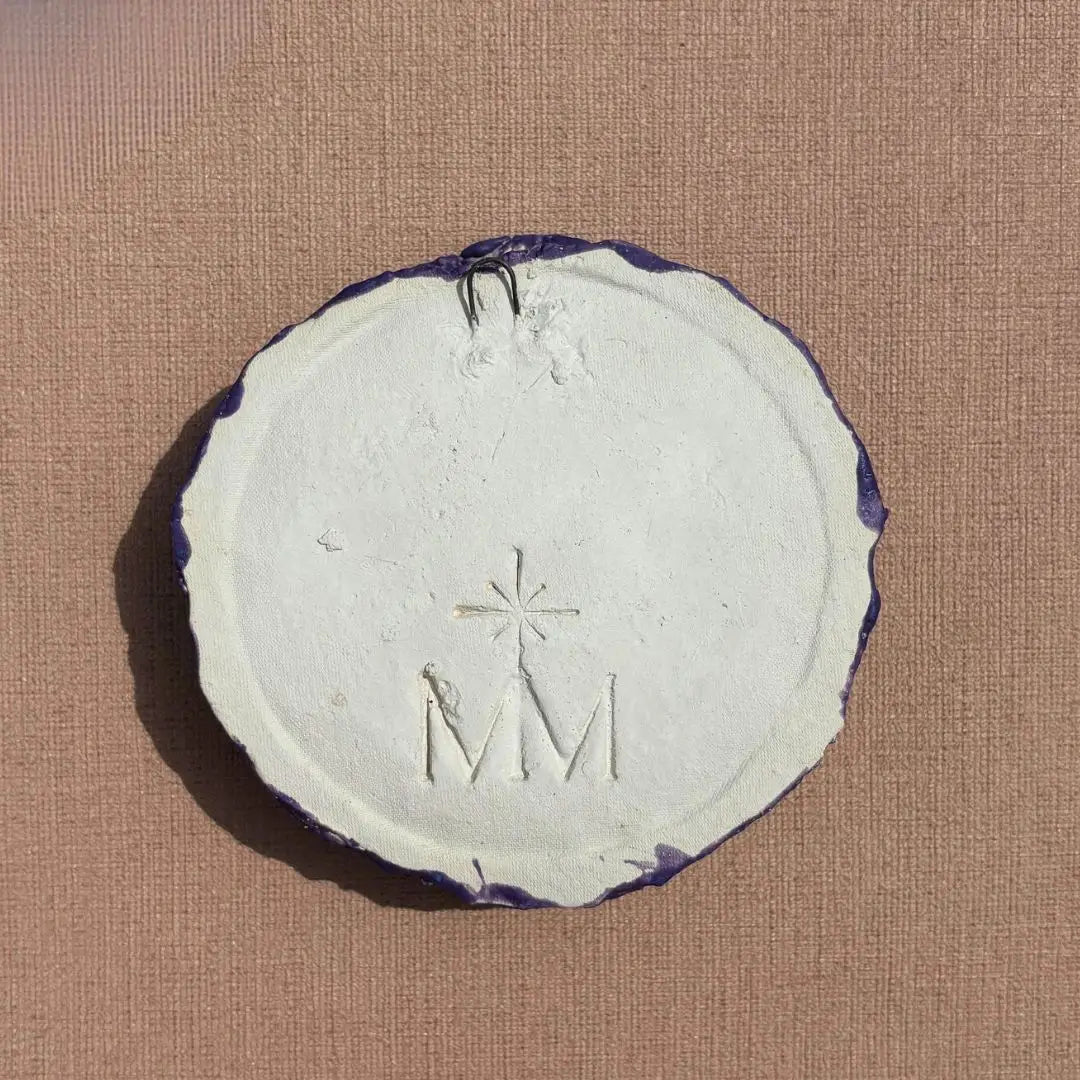 Achterkant van keramiek klaproos met ingegraveerd Magical Moments logo